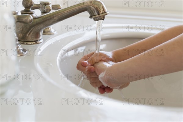 Close-up of girl (6-7) washing hands