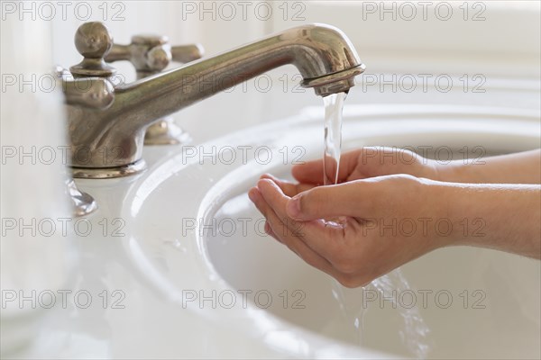 Close-up of girl (6-7) washing hands