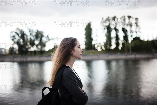 Woman walking near lake in cloudy weather