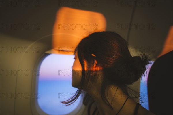Portrait of young woman in plane illuminated with sunset light