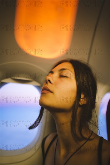 Portrait of young woman in plane illuminated with sunset light