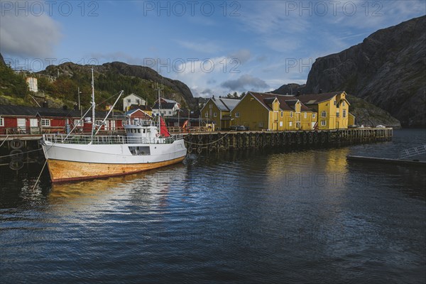 Norway, Lofoten Islands, Nusfjord, Fishing boat in dock in traditional fishing village