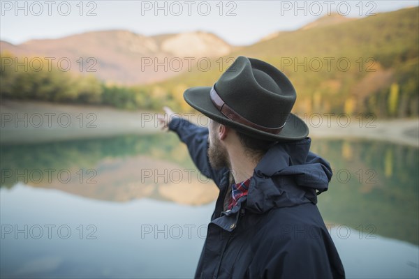 Italy, Man pointing towards mountains