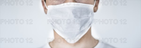Studio shot of teenage boy (16-17) wearing protective mask