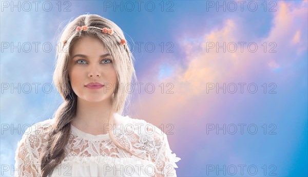 Woman wearing flower crown against overcast sky