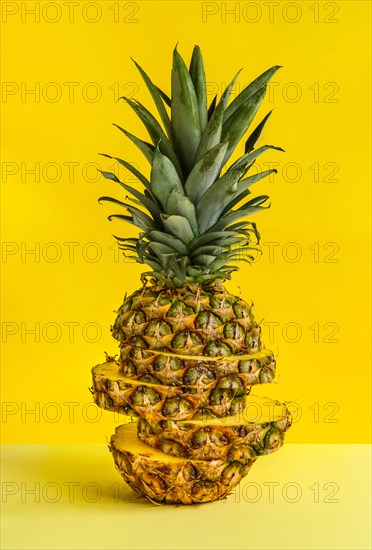 Sliced pineapple against yellow background