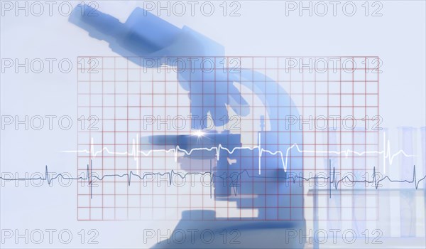 Silhouette of microscope behind electrocardiogram