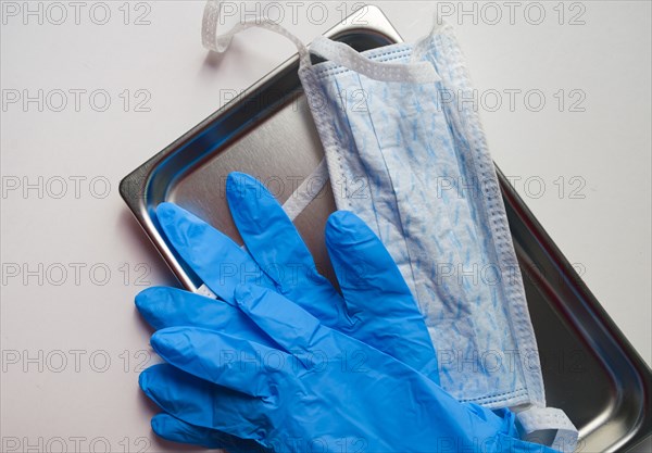 Latex gloves and hygiene mask on tray