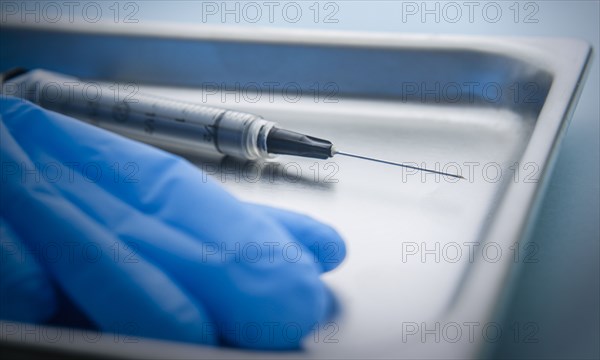 Needle and latex gloves on tray