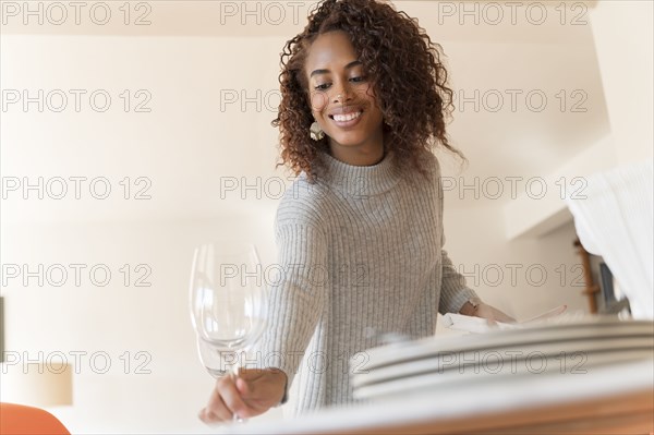 Smiling woman setting dinner table