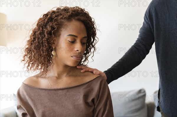 Person with their hand on sad woman's shoulder