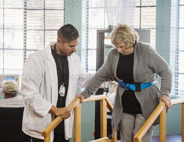 Doctor helping senior woman walk down steps