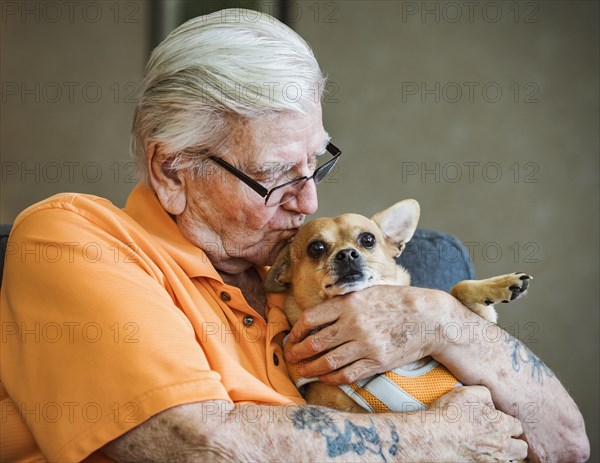 Senior man kissing dog