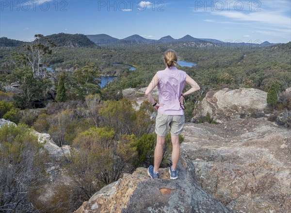 Woman standing on rock by forest