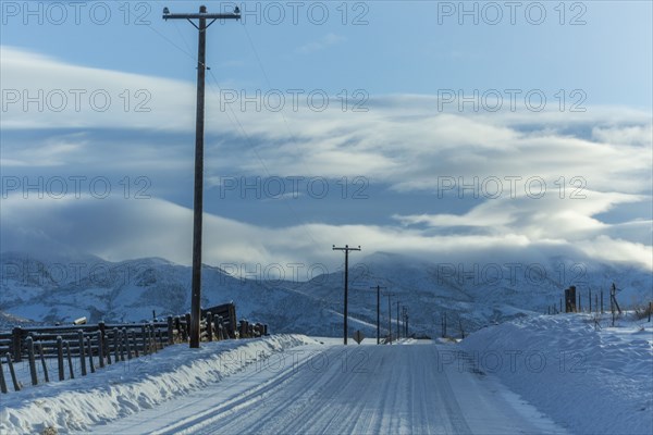 Snowy road with mountains in distance