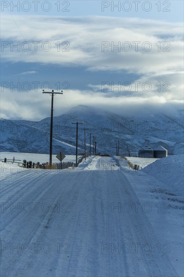 Snowy road with mountains in distance
