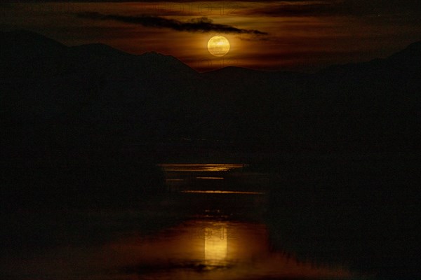 Lake under dramatic sky at night