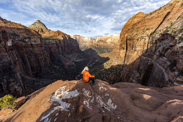 Woman sitting on cliff at Zion National Park in Utah, USA