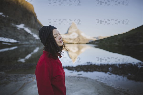 Woman standing by Matterhorn mountain and lake in Valais, Switzerland