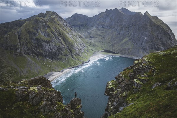 Man standing on cliff at Ryten mountain in Lofoten Islands, Norway