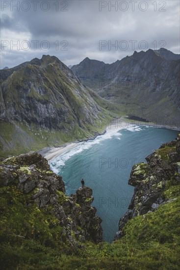 Man standing on cliff at Ryten mountain in Lofoten Islands, Norway