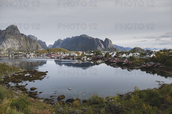 Village by lake and cliffs in Lofoten Islands, Norway