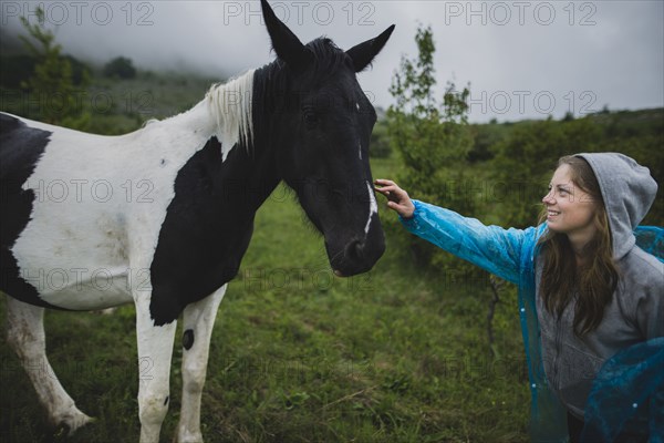Smiling woman petting Icelandic horse