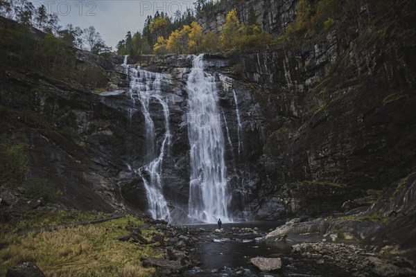 Person standing by Skjervefossen waterfall in Norway