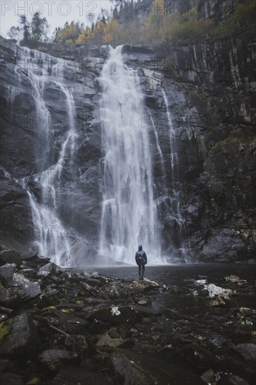 Man standing by Skjervefossen waterfall in Norway