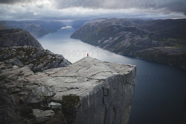 Person standing on Preikestolen cliff in Rogaland, Norway