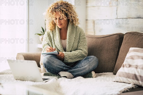 Smiling woman working with laptop on sofa