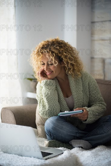 Smiling woman working with laptop on sofa