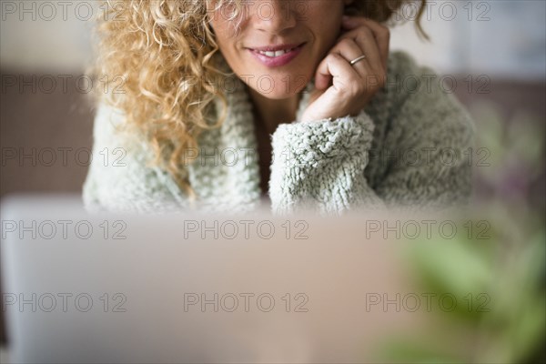 Woman smiling behind laptop