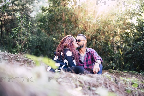 Kissing couple sitting on grass