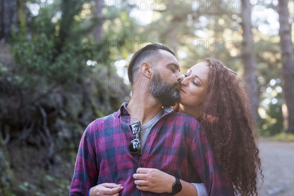 Couple kissing by trees