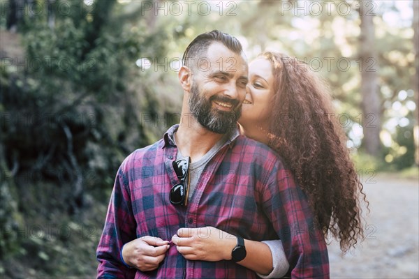 Smiling couple embracing by trees