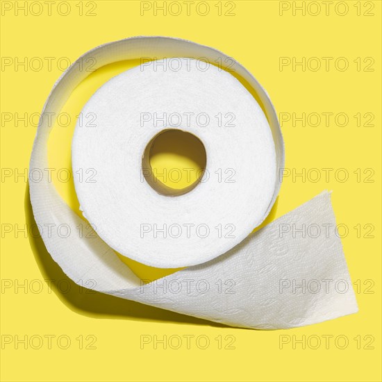 Toilet paper roll on yellow background