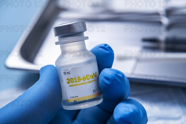 Close-up of gloved hand holding vial of Coronavirus vaccine