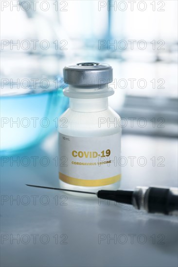 Vial of covid-19 vaccine and hypodermic needle