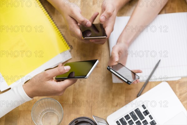 Coworkers using smart phones together