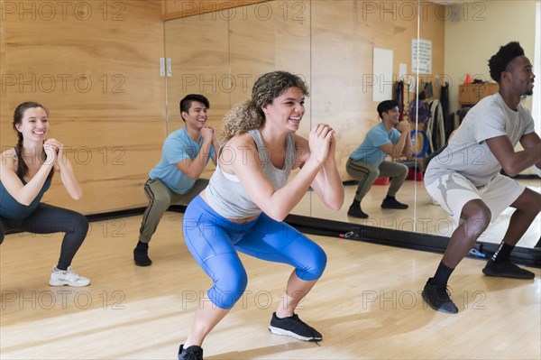 Men and women exercising in workout class