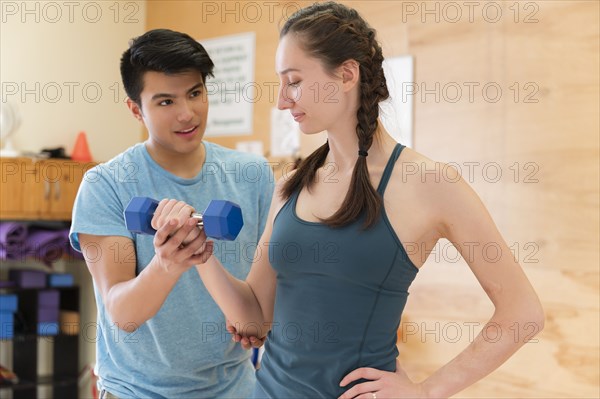 Woman working with trainer at gym