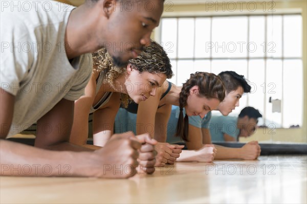 Group of friends doing planks in exercise class
