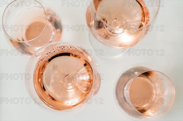 Glasses of rose wine on white background