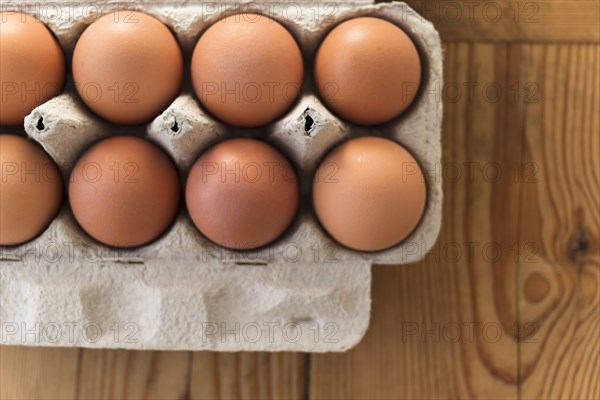 Eggs in carton on wooden table