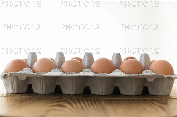 Carton of eggs on wooden table