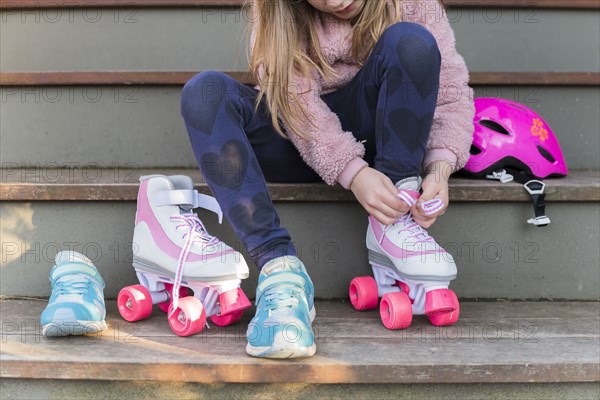 Girl tying the laces of her roller skates