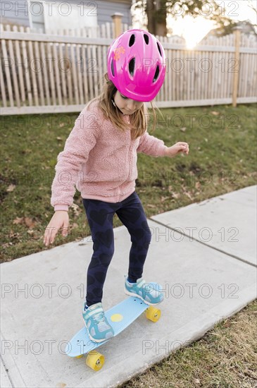 Girl skateboarding down a sidewalk