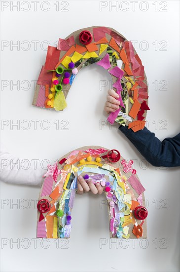 Kids hands holding their rainbow arts and crafts