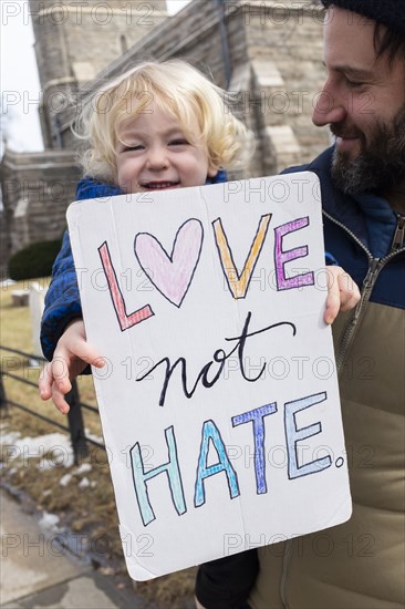 Father with little son holding peaceful protest sign